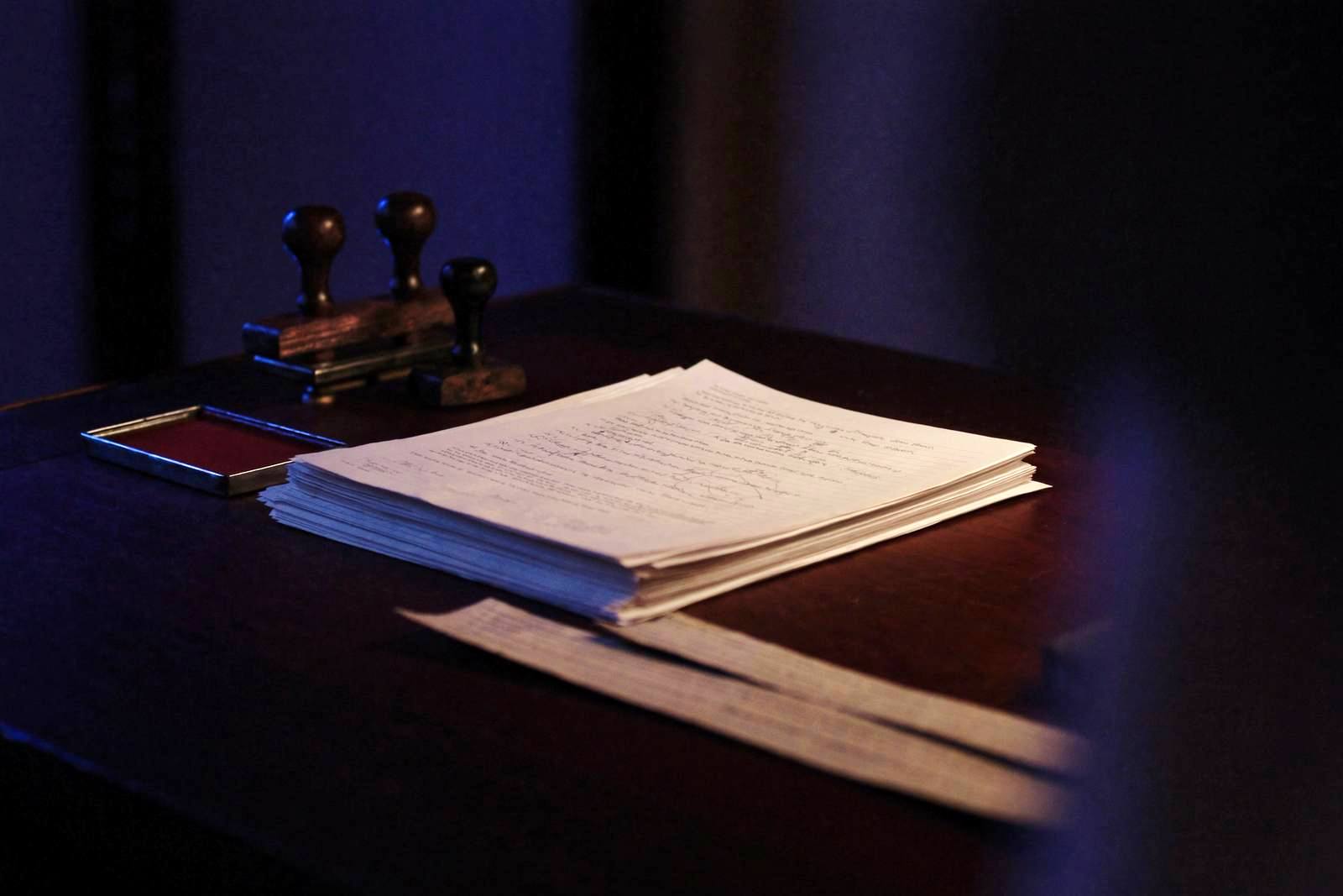 Pile de documents officiels et tampons encreurs sur un bureau