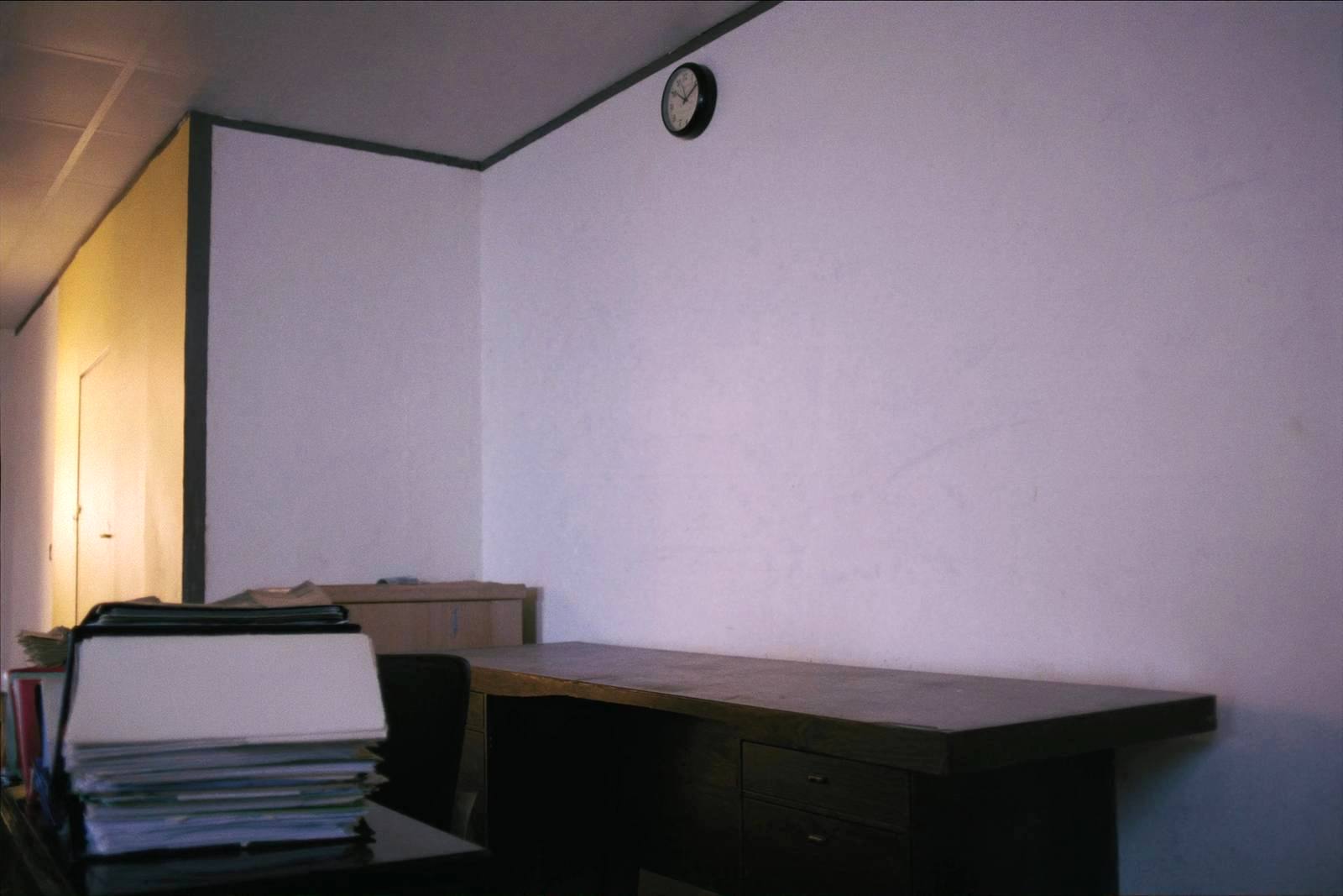 Horloge murale au-dessus d'un bureau couvert de chemises fermées